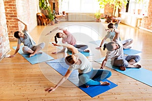 Group of people doing yoga exercises at studio