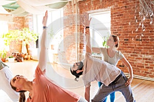 Group of people doing yoga exercises at studio