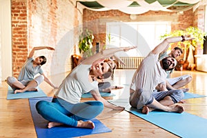 Group of people doing yoga exercises at studio