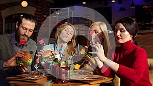 A group of people eating fast food in a modern restaurant. Slow motion.