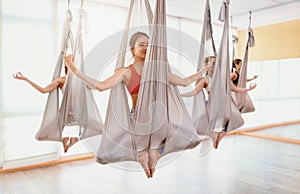 Group of people engaged in a class of yoga Aero in hammocks antigravity