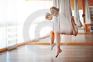 Group of people engaged in a class of yoga Aero in hammocks antigravity