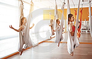 Group of people engaged in a class of yoga Aero in hammocks antigravity