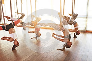 Group of people engaged in a class of yoga Aero in hammocks antigravity