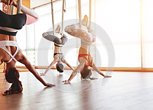 Group of people engaged in a class of yoga Aero in hammocks antigravity