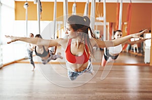 Group of people engaged in a class of yoga Aero in hammocks antigravity