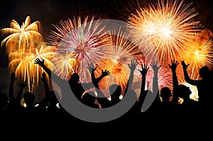 Group of people enjoying spectacular fireworks show in a carnival or holiday