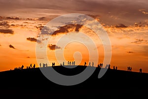 Group of people enjoying the sunset on hill