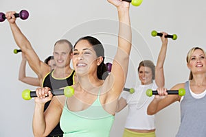 Group Of People Exercising In Dance Studio With Weights