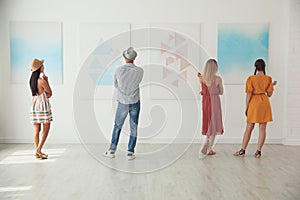 Group of people at exhibition in art gallery photo