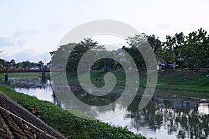 A group of people fishing by the river on the outskirts of the city