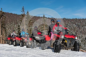 Group of people on four-wheelers ATV bikes on snow in winter