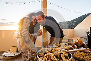 Group of people friednship concept have fun together taking selfie during a dinner or lunch outdoor at home in the terrace -