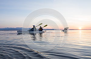 Group of people friends sea kayaking together at sunset in beautiful nature. Active outdoor adventure sports