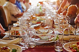 A group of people gathered around a long table in a restaurant or cafe.  Served with glasses and Cutlery, fruit dishes and snacks