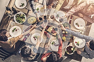 Group of people having meal togetherness dining toasting glasses