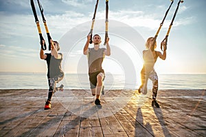 Group of people having Trx training
