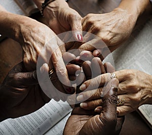 Group of people holding hands praying worship believe