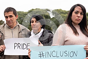 A group of people holding inclusiÃÂ³n and pride signs as a protest. LGBT Concept photo