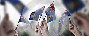 A group of people holding small flags of the Cayman Islands in their hands