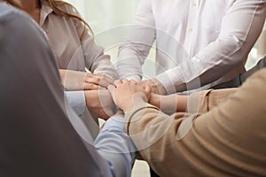 Group of people holding their hands together on blurred backgroundp
