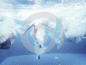 Group of people jumped down to the swimming pool underwater shot photo