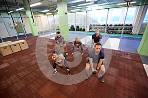 Group of people with kettlebells exercising in gym