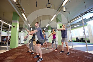 Group of people with kettlebells exercising in gym