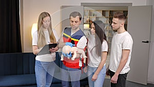 Group of people learning how to make first aid with dummy child during the training indoors