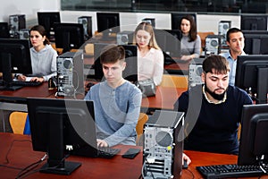 Group of people learning to use computers in classroom