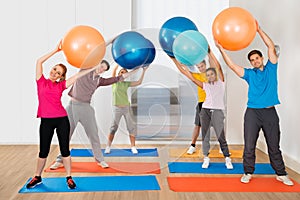 Group Of People Lifting Pilates Ball photo