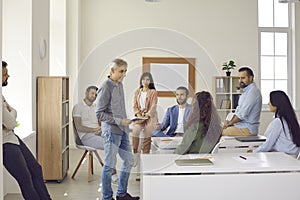 Group of people listening to coach during business training in classroom or office