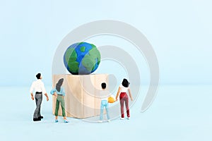 Group of people looking at earth model. Concept of environmental knowledge and sustainability