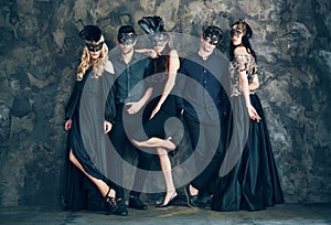 Group of people in masquerade carnival mask posing in studio