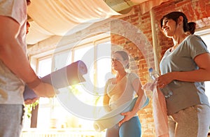 group of people with mats at yoga studio or gym