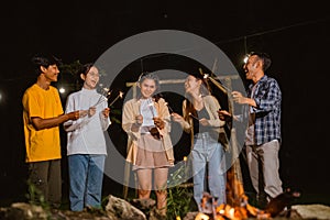 a group of people playing with the fireworks happily at the night