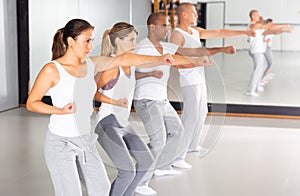 Group of people practicing self defense movements in training room