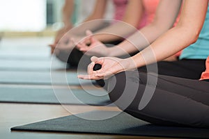 Group of people practicing yoga class, hands closeup background, sport and healthy lifestyle, wellness, well being photo