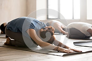 Group of people practicing yoga, doing Child pose, close up