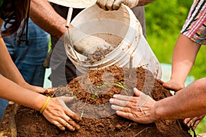 Group of people preparing clay dirt for pottery, close-up