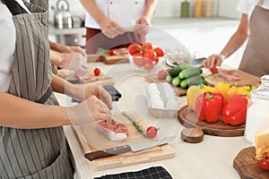 Group of people preparing meat at cooking classes