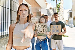 Group of people protesting and giving slogans at the street pointing with finger to the camera and to you, confident gesture