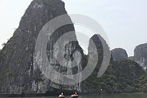 A group of people are on a raft in the sea near a mountain in Ha Long Bay Hanoi Vietnam photo