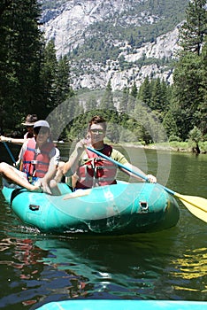 Group of People Rafting Down the River