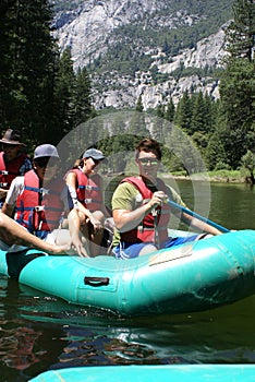 Group of People Rafting Down the River