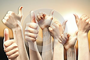 group of people raise their thumbs up b