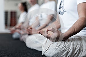 Group of people relaxes and meditate and doing stretching exercises in fitness studio. Yoga or pilates training. Close-up