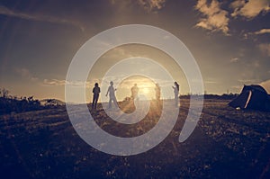 Group Of People relaxing on field with Sunset Concept