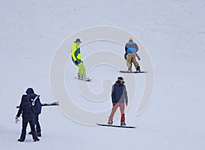 A group of people are riding snowboards down a snow-covered hill