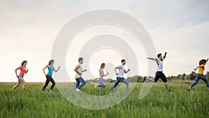 Group of people running in the grass,